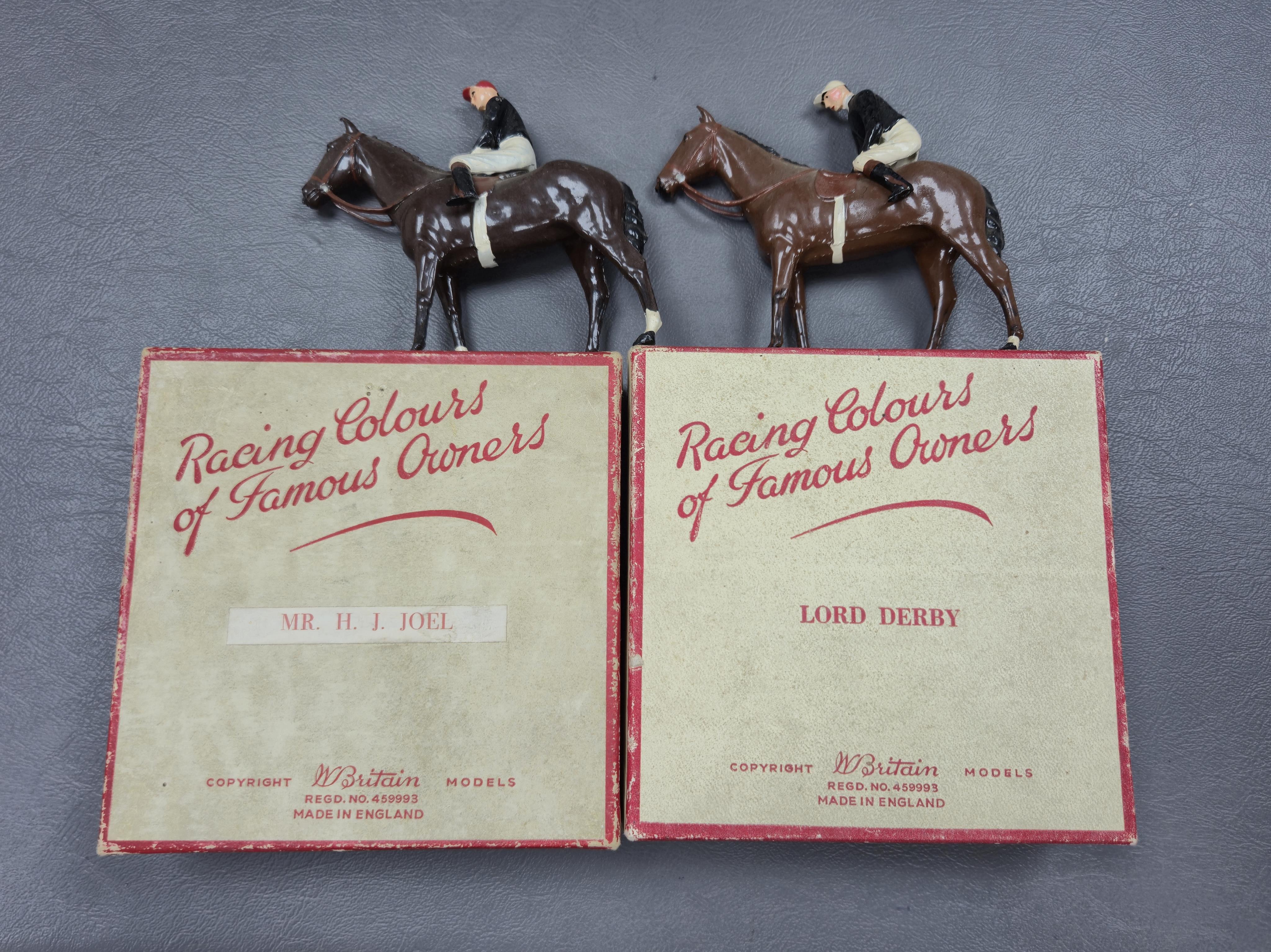Two boxed Britains Racing Colours of Famous Owners series lead mounted figures; H.M. The Queen - rider in purple and brown jersey with gold frogging on a brown horse, and H.H. The Aga Khan - rider in dark green jersey on